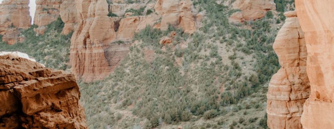 a man under an arch in a mountain range.