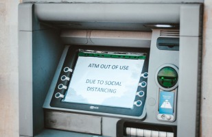 An ATM whose screen displays " ATM out of use due to social distancing"